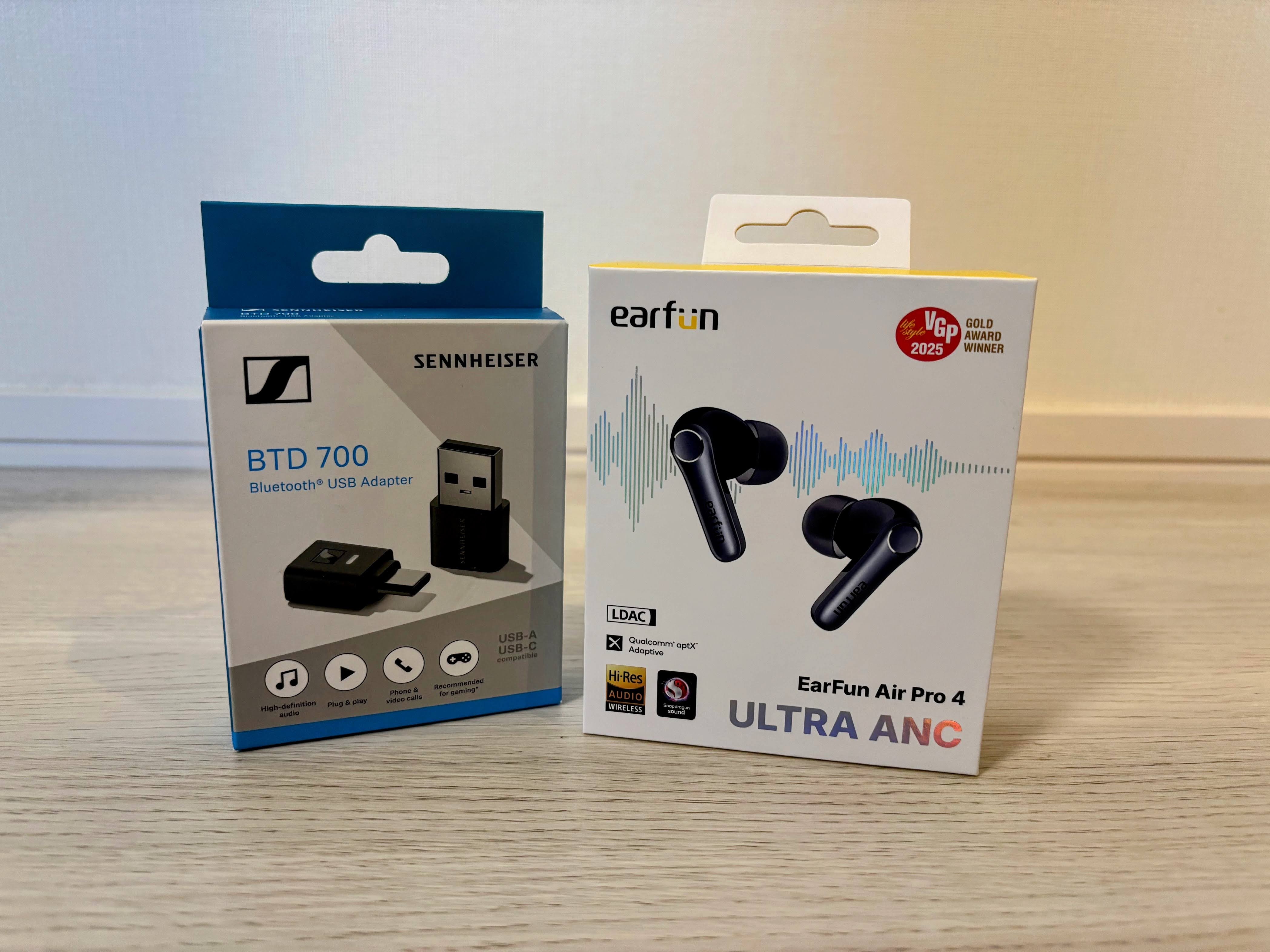 EarFun Air Pro 4ワイヤレスイヤホン(黒色、ケース付き)とSennheiser BTD 700 Bluetoothドングル(USB-C接続)を並べて配置した製品写真